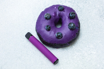 Delicious purple donut paired with a purple vaping device on a silver background