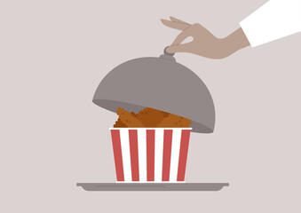 Tender and crispy chicken wings are presented in a striped container, enticing diners with their golden-brown colo, A hand lifts the dome, revealing this savory delight