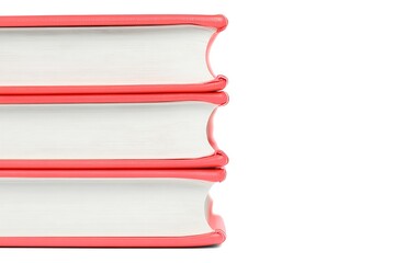 Stack of coral-colored books arranged on a white background for studying