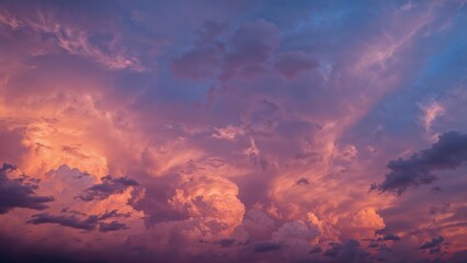 Fototapeta premium Vibrant evening sky filled with multicolored clouds and dramatic storm formations at sunset.