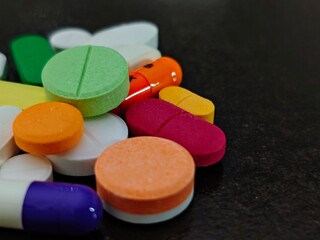 Colorful Pharmaceutical Pills A CloseUp of Medication Variety on Dark Surface.