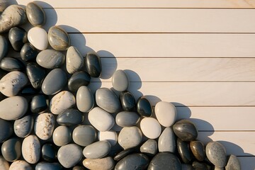 A Collection of Smooth, Gray and Black River Rocks Arranged on a Light Wooden Surface