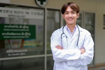 Young healthcare worker wearing lab coat in front of medical clinic