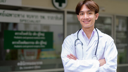 Young healthcare worker wearing lab coat in front of medical clinic