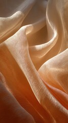 Soft, flowing beige fabric with a delicate texture, illuminated by warm light creating smooth folds and shadows.