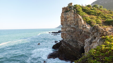 Rugged coastal cliffs at Shenzhen Head with crashing waves and cloud formations in Lian Jia Park, South China Sea vista