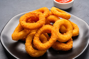 Fried onion rings on black background
