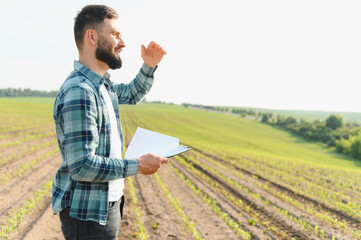 Agronomist inspecting corn field growth and taking notes