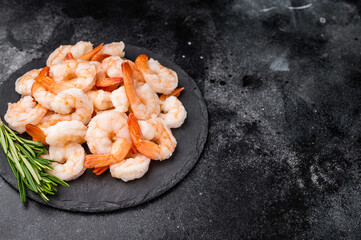 A plate of shrimp with a sprig of rosemary on top. The shrimp are arranged in a way that they are not overlapping each other.