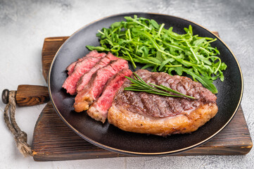 Tender grilled striploin New York steak paired with fresh vegetables, the ultimate comfort food for any occasion. white background. top view