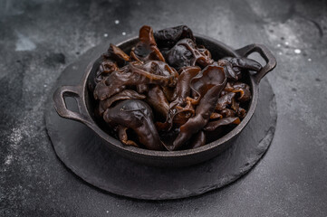 A bowl of fresh wood ear mushrooms, perfect for health conscious cooks seeking nutritious and flavorful ingredient. black background. top view
