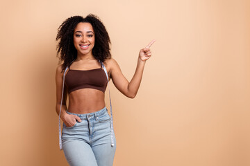 Attractive young woman with measuring tape, promoting a healthy lifestyle, wearing stylish casual...