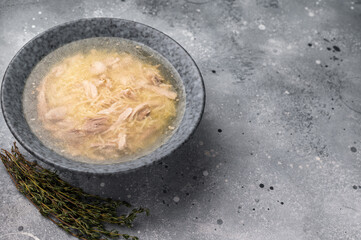 Chicken soup with Vermicelli and meat in a plate. grey background. top view