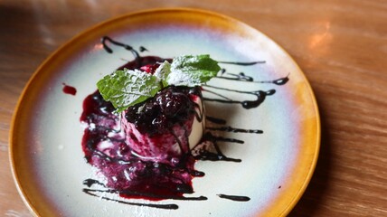 close up of white chocolate panna cotta with blueberry sauce on a dish with copy space 