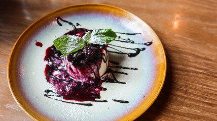 close up of white chocolate panna cotta with blueberry sauce on a dish with copy space 