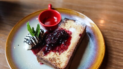 Close up of french toast with blueberry sauce and syrup on the side on a plate, copyspace on the right