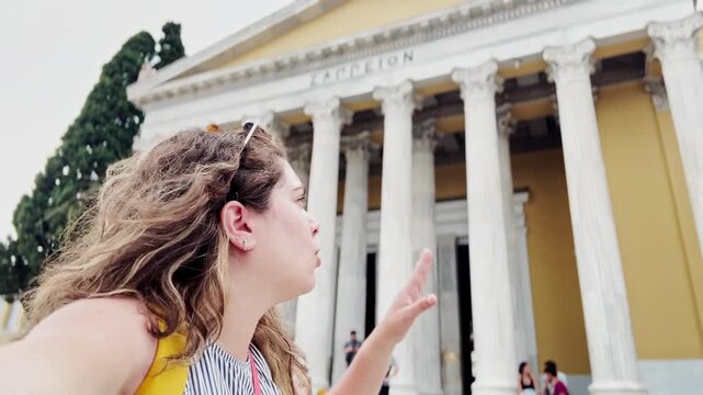 Young Woman Pointing at Zappeion Hall While Vlogging in Athens