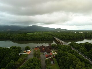 Morning traffic on bridge with river and mangrove area.