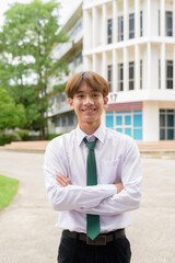 Happy non binary university student smiling in college campus