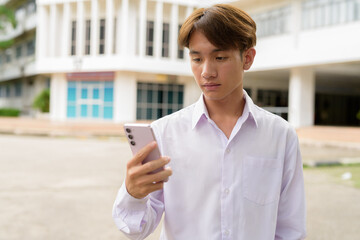 Fototapeta premium University student using phone in campus
