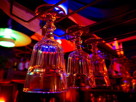 Cocktail and wine glass hanging over bar counter. - Powered by Adobe