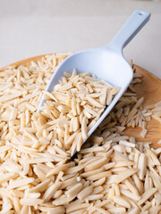 White Almond Stick set on wooden board with versatile scoop and white background.