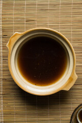 Overhead view of soy sauce soup in a claypot, top view of soy sauce broth