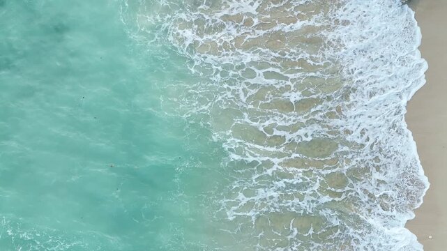 Top Aerial View of Tropical Beach in Bali, Indonesia. Empty paradise beach, blue sea waves in Bali island, Indonesia