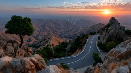 Scenic Mountain Road Winding Through Dramatic Landscape at Sunset