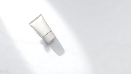 Minimalist white cosmetic tube with soft shadow on a clean white marble surface