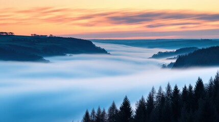 Fototapeta premium Serene misty landscape at dawn, showcasing valleys and forests under a colorful sky
