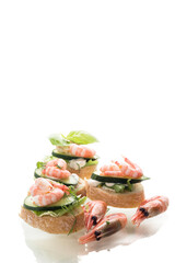 Portioned appetizers with shrimps, salad leaves and sauce isolated