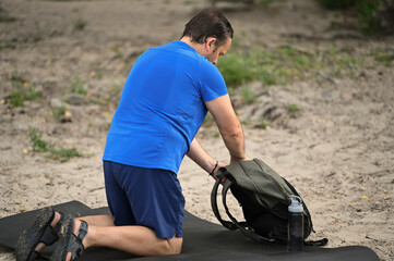 Obraz premium a tourist with a backpack walks along the river beach
