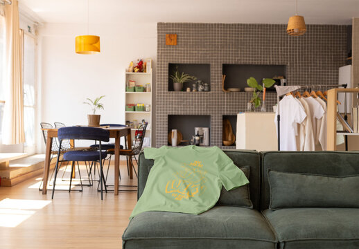 T-shirt mockup draped over a cozy sofa.