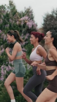Vertical video, Four diverse women enjoy their morning jog, chatting as they go. Their fitness routine is a testament to health and friendship.