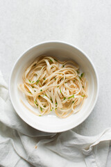 Overhead view of noodles in a bowl, top view of egg noodles on a white background