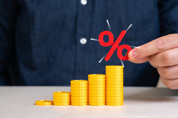 Growing stack of coins and percentage symbol. Capital growth and increase of savings on deposit and...