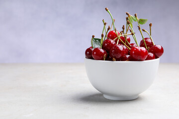 Wet ripe cherries on light table, closeup. Space for text