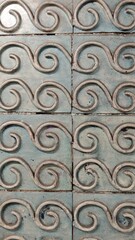 Blue ceramic tiles with embossed swirl pattern creating a decorative surface