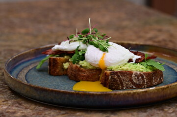 Avocado Toast with Poached Eggs, Bacon and Microgreens – Gourmet Breakfast Close-Up
