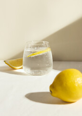 a cold clear glass of lemonade on the table illuminated by a bright light