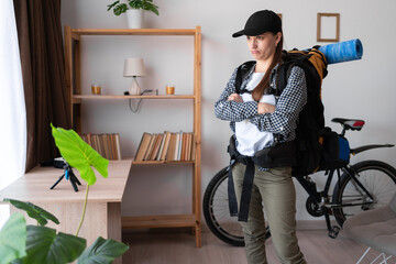 Unhappy Displeased woman ready to hike vacation puffed cheeks standing with backpack at home