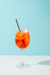Aperol Spritz, traditional summer cocktail at blue background.