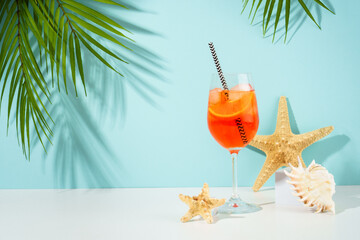 Aperol Spritz, traditional summer cocktail at blue background. Sunny tropical holidays background.