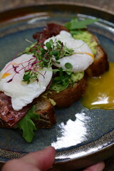 close up serving avocado toast with egg