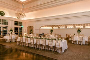 Elegant indoor banquet setup for a special event with decorated tables and floral arrangements in a luxurious venue