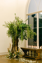 Elegant indoor floral arrangement with greenery and candles illuminating the space at a special...