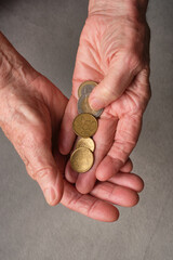 Hands of an elderly person with money, coins. Selective focus