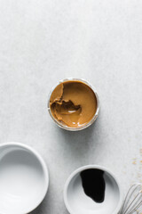 Overhead of ingredients for making peanut butter sauce, mise en place of ingredients for making creamy peanut sauce soy sauce sugar vinegar, process of making peanut sauce 