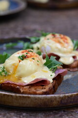 Eggs benedict with ham, rucola and cheese, closeup, serving breakfast menu